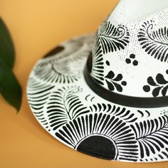 This Maite Artisanal Hat is crafted with care by Alicia in Oaxaca, Mexico. Its distinctive, hand-painted design stands out with vibrant colors and fun patterns, creating a stylish and versatile accessory suitable for any season. Traditional Mexican aesthetics get a modern twist in this beautiful, curated selection of hats. Size: Medium 22.8 inches. One size fit most; hat features an internal elastic band for comfort. Materials: Painted jute. The hat brim features a leather band and colors of ban Leather Band, Cool Patterns, Twist, Vibrant Colors, Hand Painted, Hats, Leather, Pattern, Color