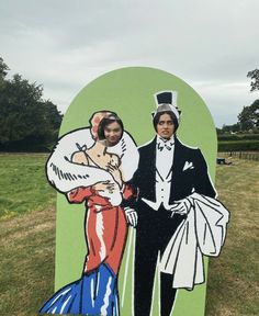 a cardboard cutout of two people standing next to each other in front of a field