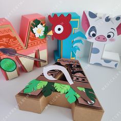 some paper animals are sitting on top of cardboard boxes and one is cut out to look like an animal