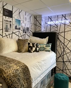 a leopard print bed in a bedroom with black and white wallpaper on the walls