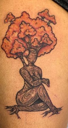 a woman with a tree tattoo on her back and legs, sitting in the lotus position