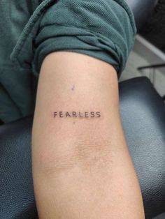 the word fearless is written on someone's leg