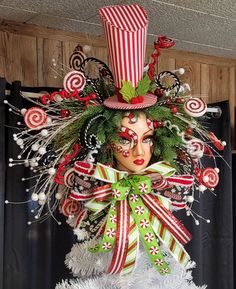 a woman wearing a christmas wreath with candy canes on her face and green hair