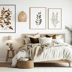 a bed with white sheets and pillows next to two pictures on the wall above it