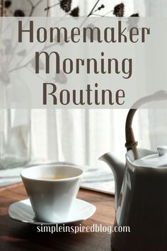 a white teapot sitting on top of a wooden table next to a cup and saucer