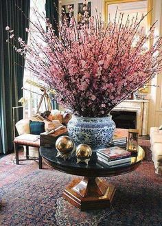 a living room filled with furniture and a large vase on top of a coffee table