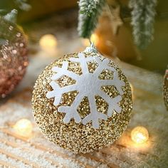 a gold and white ornament sitting on top of a table next to christmas lights