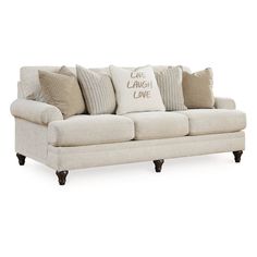 a white couch with pillows on it and the words love laugh live written in black