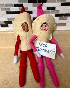 two elfs with taco tuesday written on their faces are laying next to each other