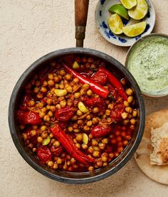 a pan filled with food next to some pita bread