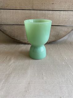 a green cup sitting on top of a wooden table