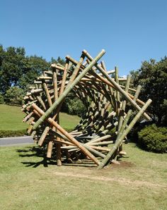 a sculpture made out of wooden sticks in the grass