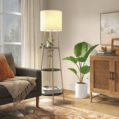 a living room filled with furniture and a tall lamp on top of a wooden floor