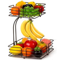 two metal baskets filled with fruit on top of each other in front of a white background