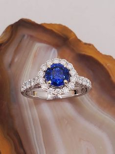 a blue and white diamond ring sitting on top of a shell