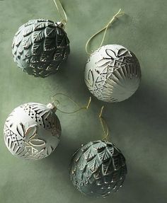 three ornaments are hanging on a green surface