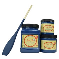 three jars of blue paint with a wooden spoon