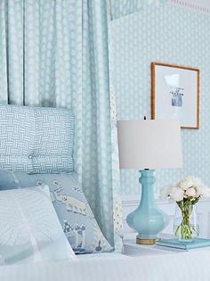 a bedroom with blue and white decor on the walls, bedding, and pillows