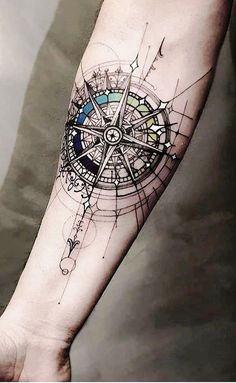 a man's arm with a compass tattoo on it