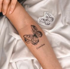 a woman's arm with a butterfly tattoo on the left side of her arm