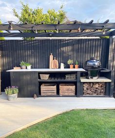 an outdoor bbq with grill and potted plants