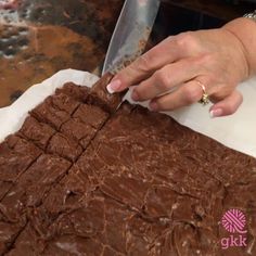 a woman is cutting into some brownies with a knife