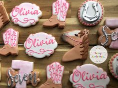 decorated cookies are arranged on a wooden table with name tags and horse boots in the center