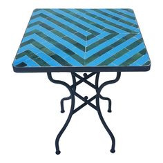 a blue and black tiled table with an iron base