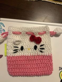 a crocheted hello kitty purse with a red bow on it's head