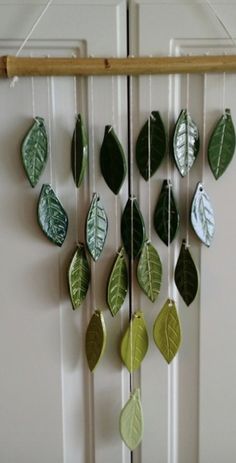 a wind chime with green leaves hanging from it