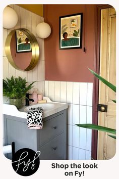 a bathroom with a sink, toilet and potted plant on the counter next to it