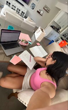 a woman is sitting on the couch with papers in front of her