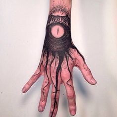 a person's hand with black ink on it and an evil eye in the middle