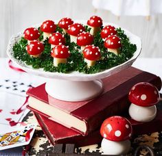 a white bowl filled with red mushrooms on top of a table