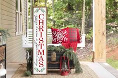 a christmas porch sign sitting on top of a wooden bench