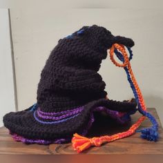 a crocheted witches hat and rope on top of a wooden table