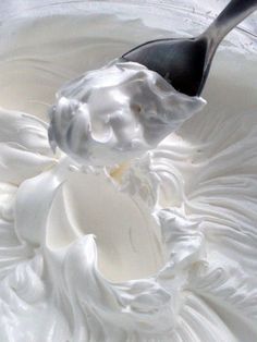 a spoon in a bowl filled with whipped cream