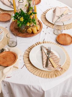 the table is set with plates and place settings