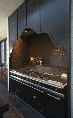 a kitchen with an oven, stove and counter tops in black wood tones is shown