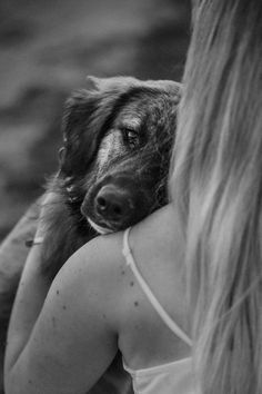 a woman holding a dog in her arms