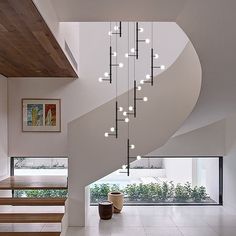 a spiral staircase with lights hanging from the ceiling