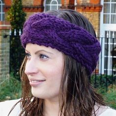 a woman wearing a purple headband in front of a brick building