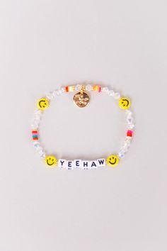 a bracelet that says yeehaw with smiley face beads and a gold heart charm