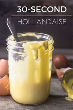 a jar filled with yellow liquid next to eggs