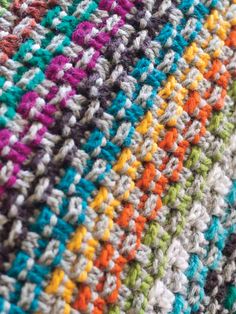 a close up view of a multicolored crocheted blanket