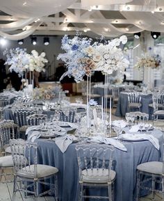 the tables are set with silver and white flowers