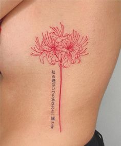 a woman's stomach with a flower tattoo on her side and the words written in japanese