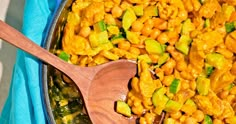 a wooden spoon sitting in a pan filled with macaroni and cheese