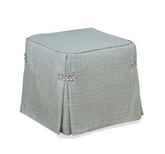 a small square ottoman cover with bows on the front and bottom, in light blue