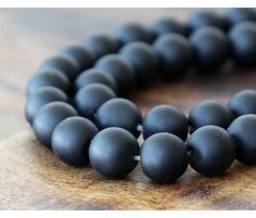 a close up of a beaded necklace on a wooden surface